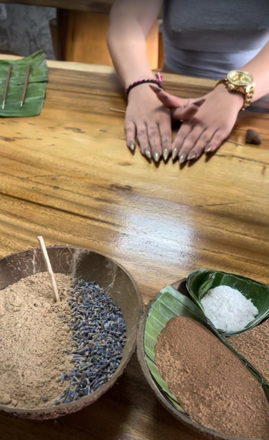Hands palm rolling incense dough beside botanical powders